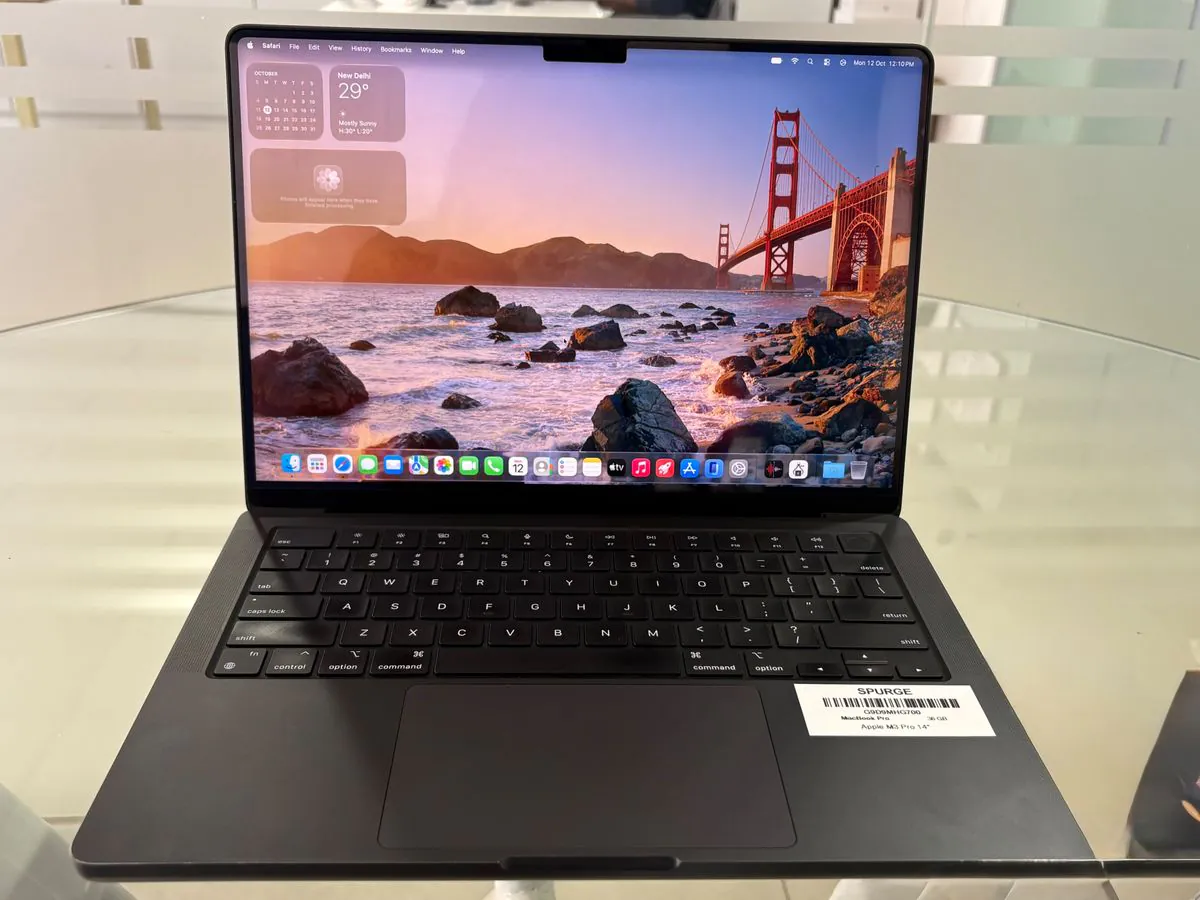 MacBook Pro 14-inch M3 Pro in Space Black, open facing the camera, showing the Liquid Retina XDR display, keyboard, trackpad and Touch ID key with a SPURGE asset label on the palm rest