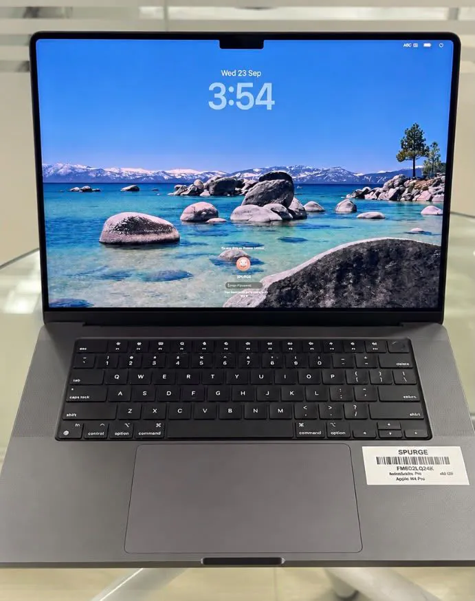 MacBook Pro 16-inch M4 Pro in Space Black, open facing the camera on the lock screen, showing the keyboard with Touch ID and the trackpad