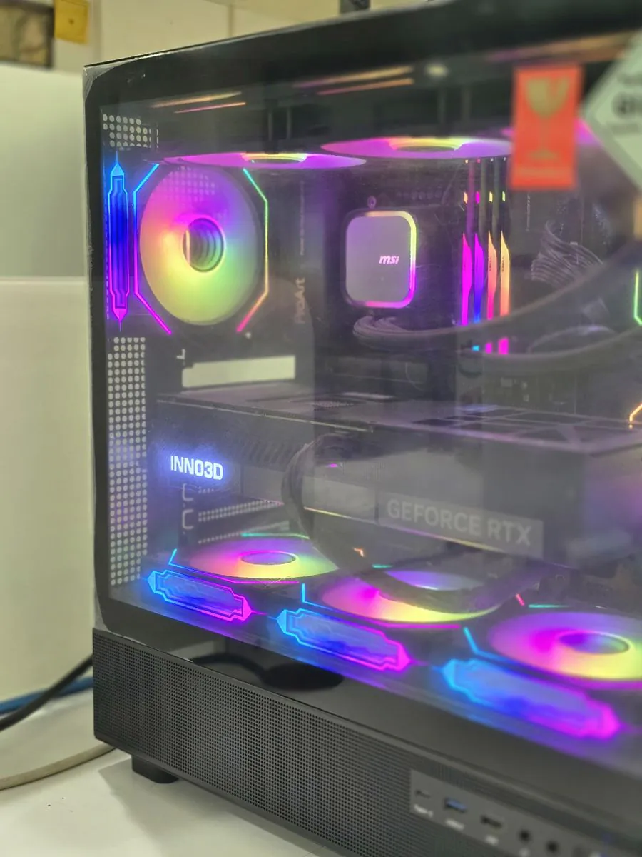 Close-up through the glass of the ASUSTeK Pro PC Z890 Creator WiFi interior, showing the ASUS ProArt motherboard, the MSI liquid-cooler pump, RGB memory modules and the Inno3D GeForce RTX graphics card