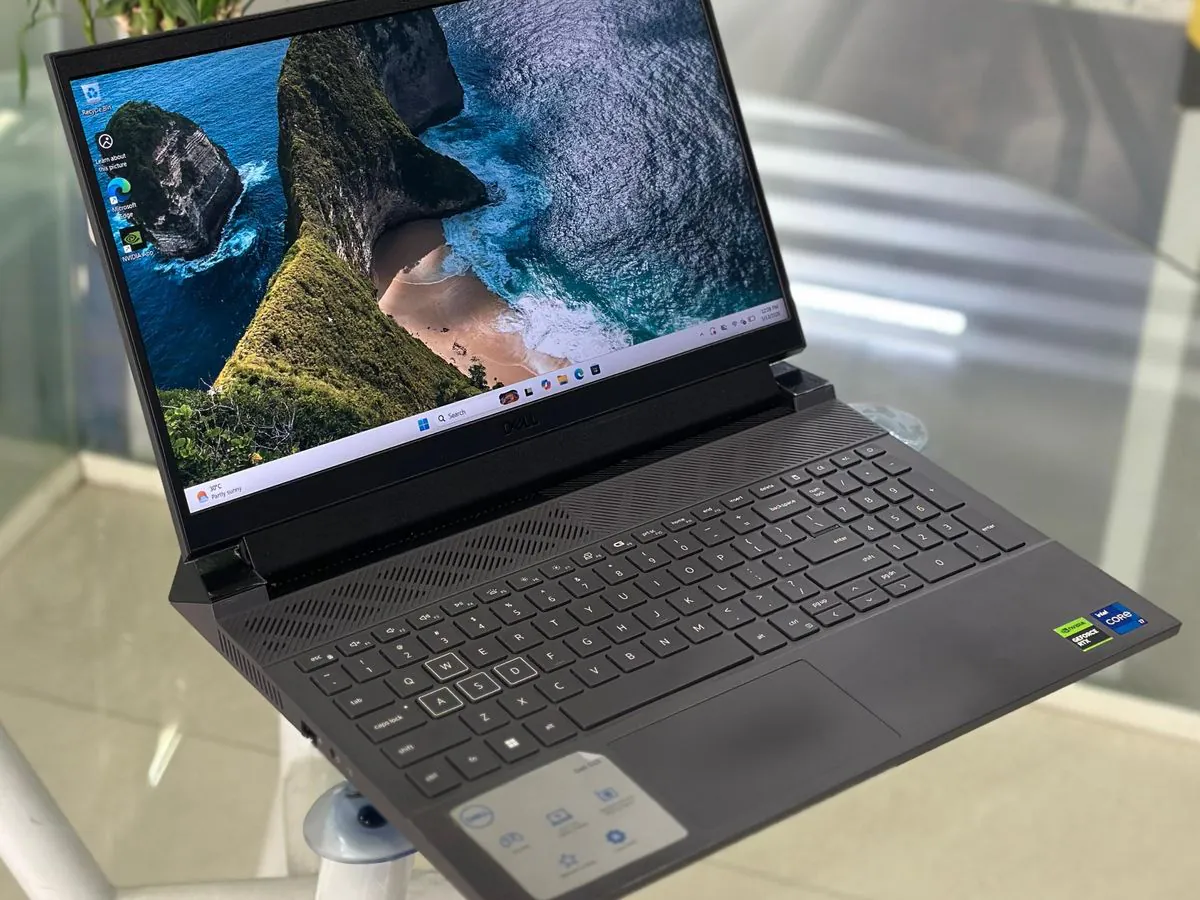 Dell G15 5530 from the left side showing the full keyboard deck, trackpad and display