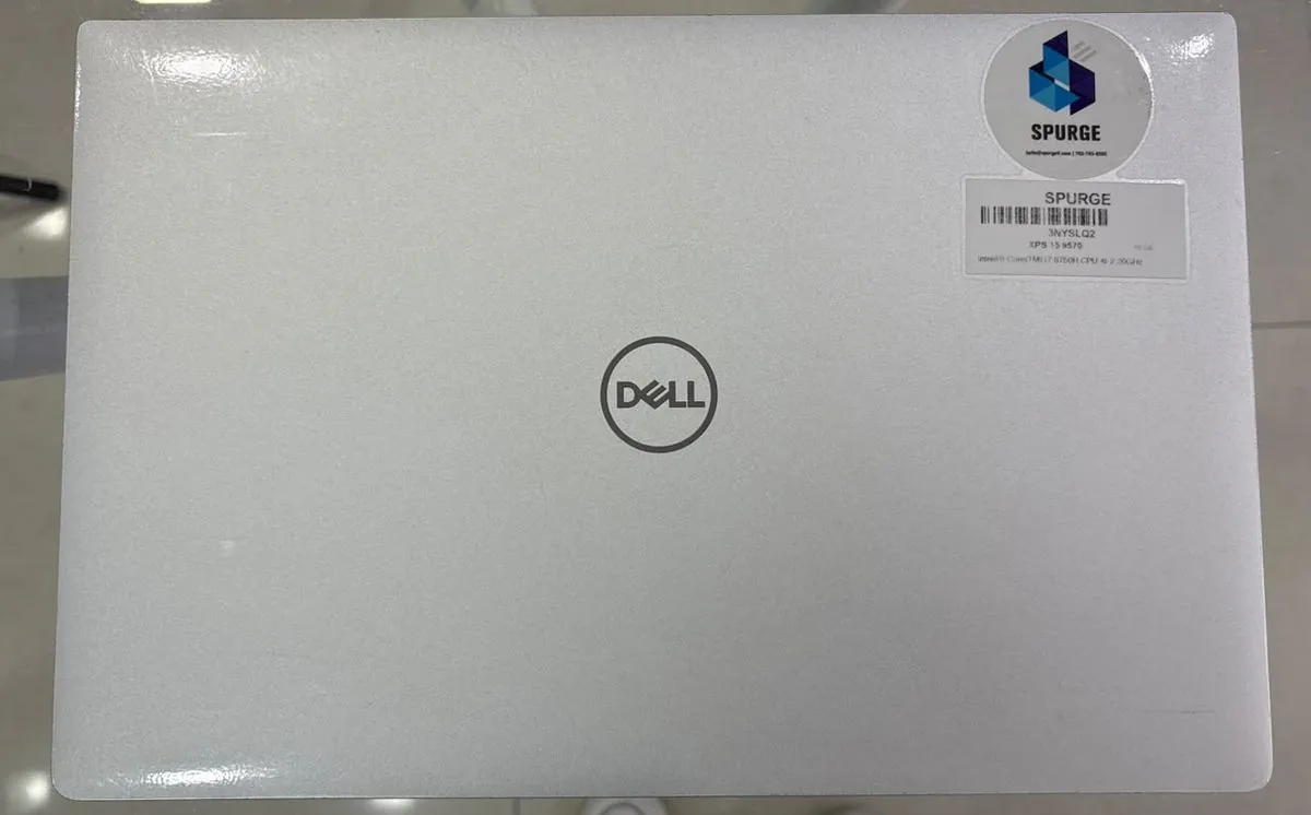Dell XPS 15 9570 closed, silver aluminium lid with the Dell logo and SPURGE asset stickers