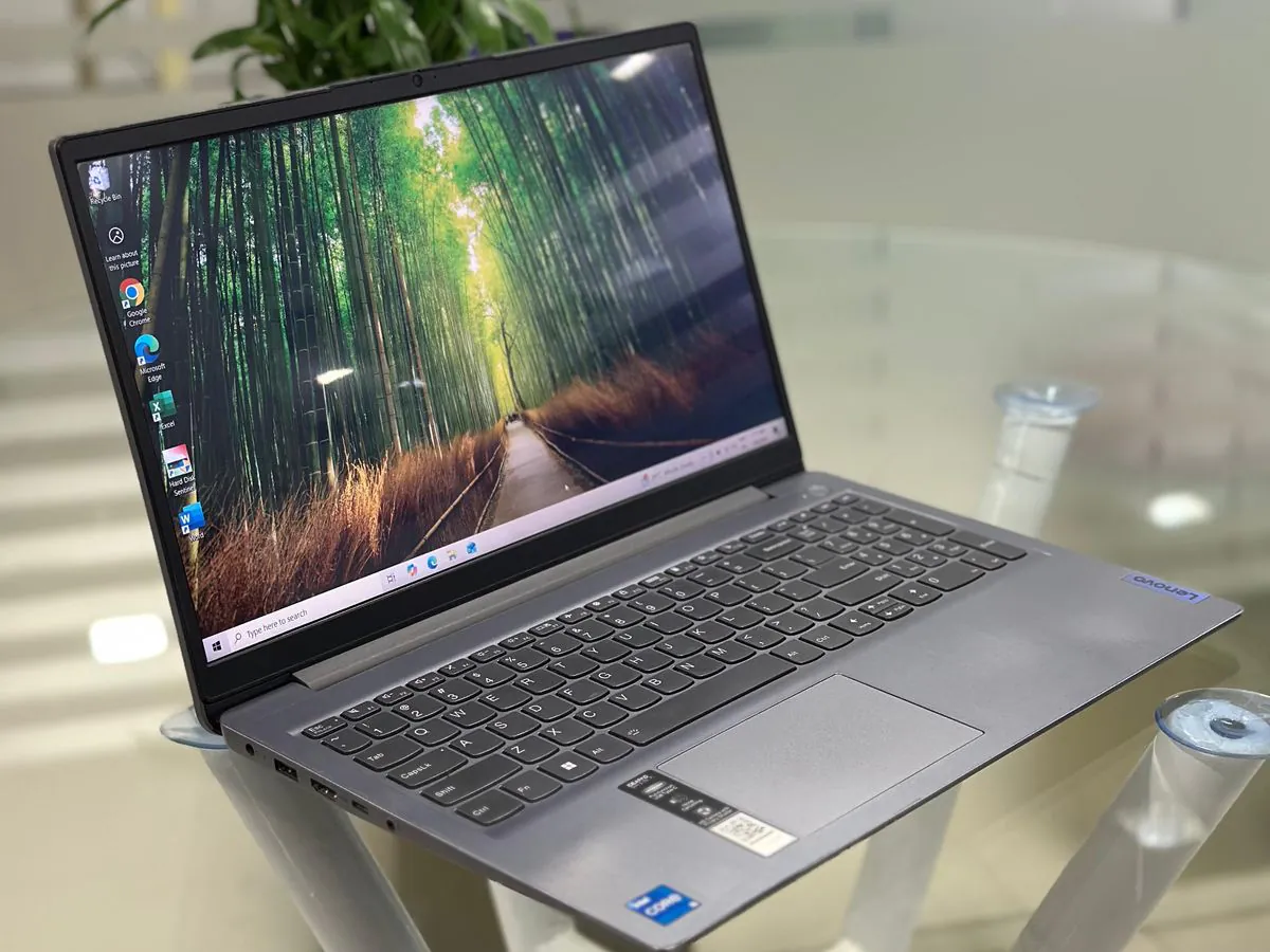 Lenovo IdeaPad Slim 3 15IAU7 from the left showing the keyboard deck, touchpad, palm-rest Intel Core i5 stickers and left-side ports with the display on