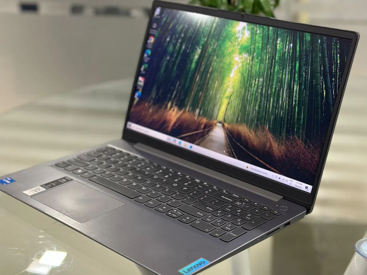 Lenovo IdeaPad Slim 3 15IAU7 from the right showing the Arctic grey deck, right-side ports and Lenovo badge with the display on