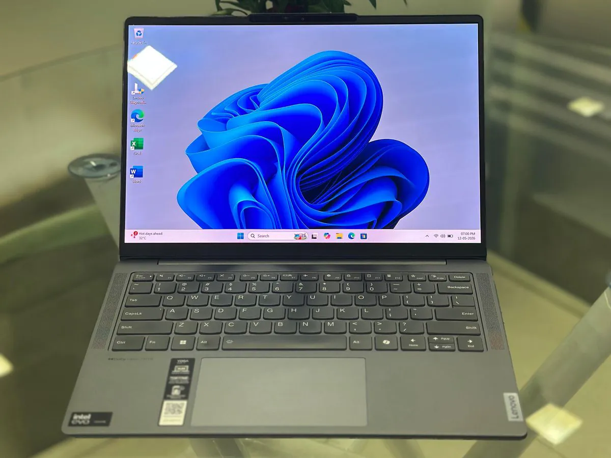 Lenovo Yoga Slim 7 14IMH9 open at an angle with the Windows 11 desktop on the 14-inch OLED display, Intel Evo and Yoga palm-rest stickers visible