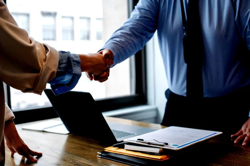A laptop handover at a business desk